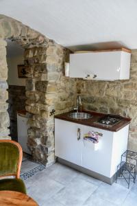 cocina con fregadero y pared de piedra en CASA LUCERTOLA, en Apricale