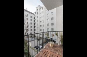 a balcony with a wooden deck next to a white building at Operastreet City Center Apartment Brasil in Vienna