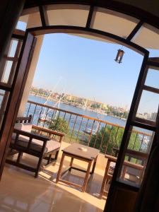 een balkon met een tafel en banken bij Luxor Plaza House in Luxor