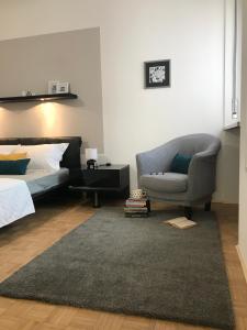 een slaapkamer met een bed, een bank en een stoel bij Gabriella's Place in Verona
