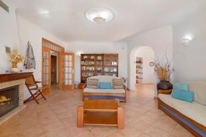 Casa do Barrocal في ألمانسيل: غرفة معيشة مع أريكة ومدفأة