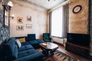un soggiorno con divano blu e TV di Native Apartments Dunajewskiego 2 a Cracovia