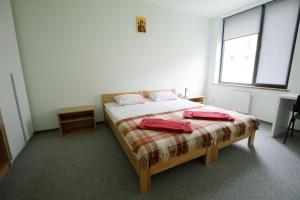 1 dormitorio con 1 cama con 2 almohadas rojas en UCU INN - Кімнати для гостей, en Leópolis