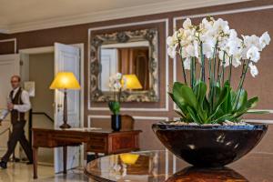 a vase of white flowers on a table in a room at Hotel Lisboa Plaza - Lisbon Heritage Collection - Avenida in Lisbon