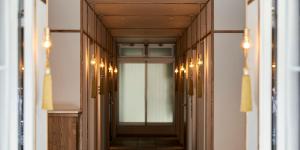 een hal met deuren en verlichting in een gebouw bij Tassel Inn Kyoto Kawaramachi Nijo in Kyoto
