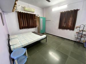 Habitación hospitalaria con 1 cama y 2 sillas en Shree Bungalow, en Ratnagiri