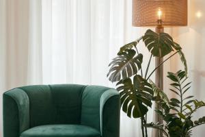 a living room with a couch, chair and a plant at RITCH Hotel Alkmaar in Alkmaar