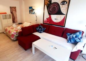 - un salon avec un canapé rouge et un lit dans l'établissement Skol 219. Studio Apartment Skol Marbella with Sea Views, à Marbella