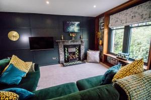 a living room with two green couches and a fireplace at Wuthering Heights in Sedbergh
