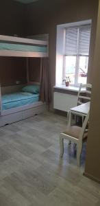 チェルカースィにあるHotel Aragviの二段ベッド、テーブル、椅子が備わる客室です。