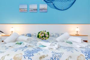 un letto blu e bianco con un mazzo di fiori sopra di Scialabà Residence Salento a Torre Pali