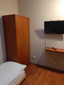 a bedroom with a bed and a wooden cabinet at Smaczny Zakątek in Ruchocice