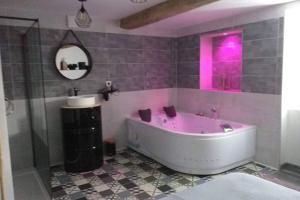 un bagno rosa con vasca e specchio di Nuit romantique a Saint-Christophe-en-Brionnais