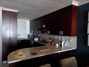 a kitchen with a counter with bananas on it at Beachfront Apartment in Cape Town