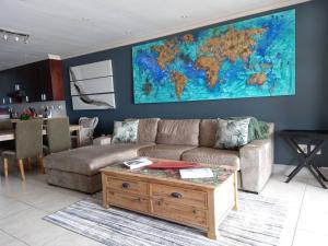 a living room with a couch and a map on the wall at Beachfront Apartment in Cape Town