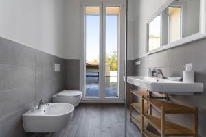 bagno con 2 lavandini e servizi igienici di Palazzo Pedretti Halldis Apartments a Bologna