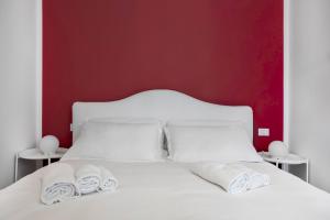 un letto bianco con due cuscini bianchi di Palazzo Pedretti Halldis Apartments a Bologna