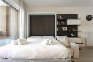 ein Schlafzimmer mit einem weißen Bett mit zwei Handtüchern darauf in der Unterkunft Pastorelli - appartamento sui Navigli con posto auto in Mailand