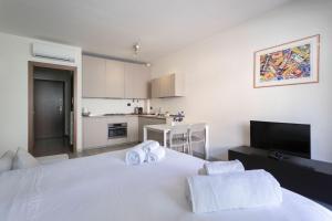 ein Schlafzimmer mit einem weißen Bett und Handtüchern darauf in der Unterkunft Pastorelli - appartamento sui Navigli con posto auto in Mailand