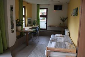 Schlafzimmer mit einem Bett, einem Schreibtisch und einem Fenster in der Unterkunft Bärchenhof in Priestewitz
