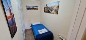 um quarto com uma cama azul e fotografias na parede em Il Tronchetto em Monte Libretti