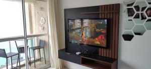 uma sala de estar com uma televisão de ecrã plano num centro de entretenimento em Porto Real Suítes Mangaratiba em Mangaratiba