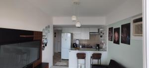 uma cozinha com armários brancos e uma bancada em Porto Real Suítes Mangaratiba em Mangaratiba