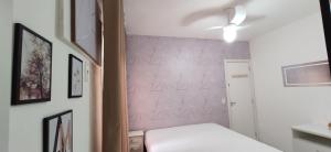a bedroom with a bed and a pink wall at Porto Real Suítes Mangaratiba in Mangaratiba +26 photos
