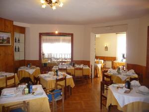 Albergo Del Sole في روكاراسو: غرفة طعام مع طاولات وكراسي مع طاولة قماش صفراء