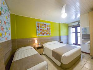 a bedroom with a bed, a desk, and a painting on the wall at Beach Hotel Maresias in Maresias