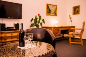 a bottle of wine sitting on a table with two glasses at Apartmenthaus Stadt Metz in Dresden