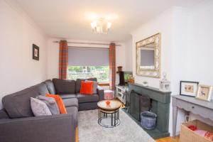 a living room with a couch and a fireplace at Fab-u-Luss in Luss