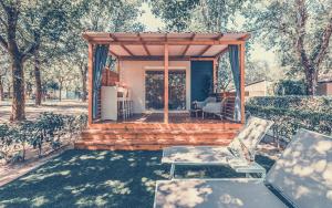 Casa con terraza de madera y silla en Resort Tenuta Primero, en Grado