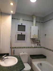 a bathroom with a sink and a toilet and a window at شقةفاخرةبجليم على البحر مباشرة in Alexandria