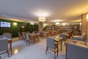 una sala da pranzo con tavoli e sedie in un ristorante di Class Hotel Guaxupé a Guaxupé