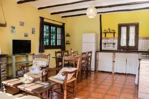 cocina y comedor con mesa y sillas en Cortijo Puerta Casas Rurales, en Órgiva