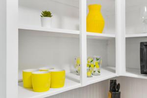 a shelf with yellow cups and vases on it at Alani Bay Villas in Fort Lauderdale