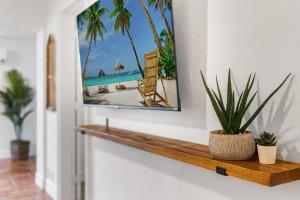 drewniana półka z roślinami na ścianie z obrazem w obiekcie Alani Bay Villas w mieście Fort Lauderdale