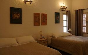 A bed or beds in a room at El Pueblito Hotel Boutique