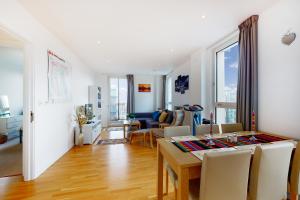 comedor y sala de estar con mesa y sillas en Lovely 2 bedroom flat with balcony in Stratford en Londres