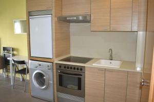 eine Küche mit einer Waschmaschine und einem Waschbecken in der Unterkunft Romántico Daimús 2 in Daimús