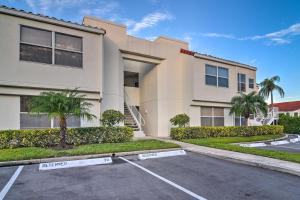 a building with a parking lot in front of it at St Pete Condo with Patio and Pool about 2 Mi to Beach in St Petersburg