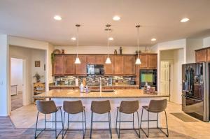 a large kitchen with a large island with stools at Sunny San Tan Valley Vacation Rental with Pool! in Magma