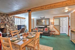 sala de estar con mesa y pared de piedra en Cozy Cottage with Spacious Yard about 4 Mi to Ski!, en Big Bear City