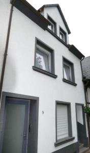 een wit gebouw met ramen en een deur bij Moselferienhaus Porten in Ellenz-Poltersdorf