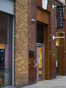 a brick building with a sign on the side of it at Cosy Studios and Apartments at Chapter Aldgate in London in London
