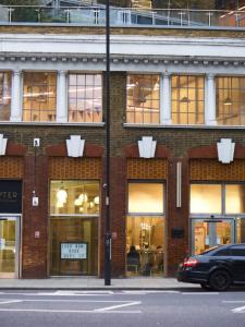 a car parked in front of a brick building at Cosy Studios and Apartments at Chapter Aldgate in London in London