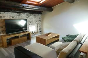 een woonkamer met een bank en een flatscreen-tv bij Greta, apartament cèntric i amb encant in Tremp