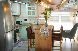 a kitchen with a table with chairs and a refrigerator at Greta, apartament cèntric i amb encant in Tremp