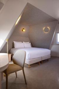 a bedroom with two beds and a chair at Hôtel Beige in Paris